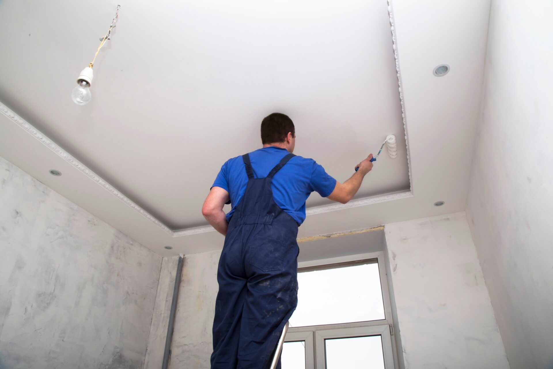 worker paints the ceiling